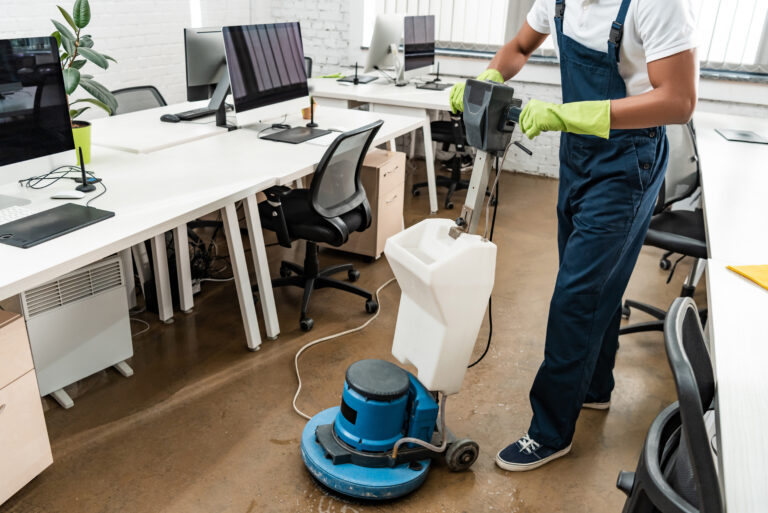 Partial view of african amercan cleaner washing floor with cleaning machine